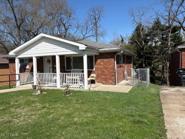 view of front of property featuring a porch, a front yard, a gate, brick siding, and fence