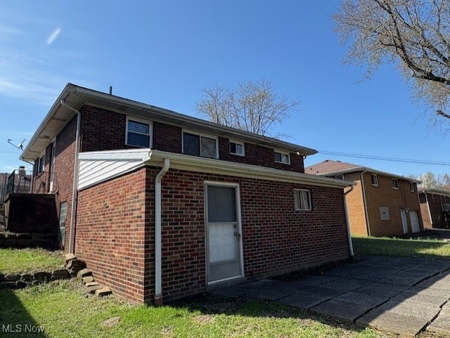 rear view of house featuring brick siding