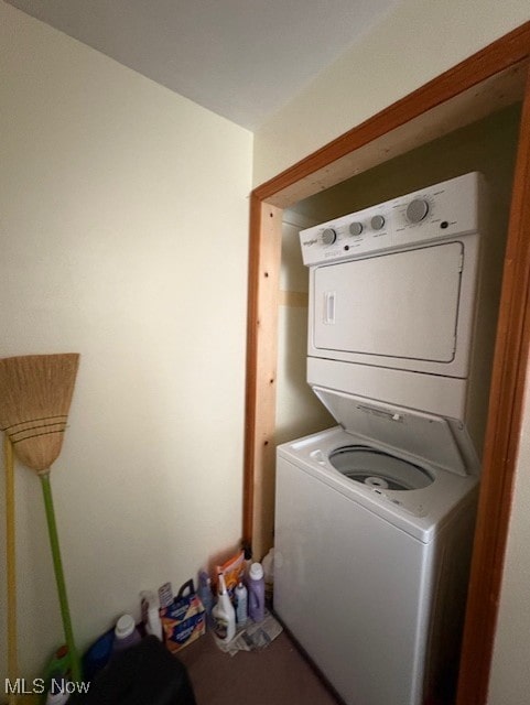washroom with stacked washing maching and dryer and laundry area