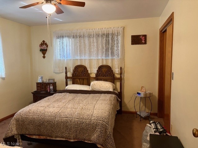 carpeted bedroom with a ceiling fan and baseboards