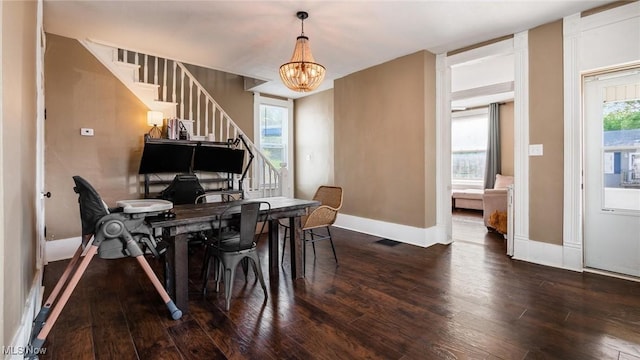 dining room with an inviting chandelier, baseboards, stairway, and wood finished floors
