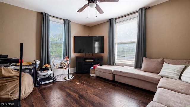 living area featuring baseboards, a ceiling fan, and hardwood / wood-style floors