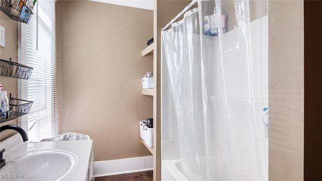 full bath featuring a sink, shower / bathtub combination with curtain, and a healthy amount of sunlight