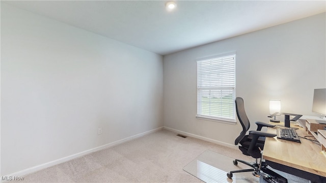 office area with baseboards, visible vents, and light colored carpet