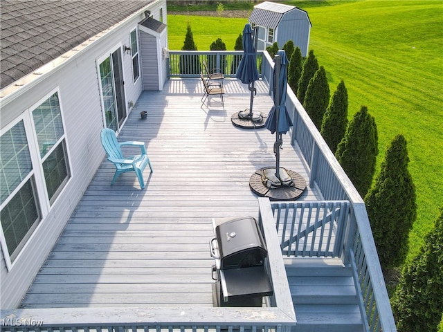 deck featuring a lawn, an outdoor structure, and stairs