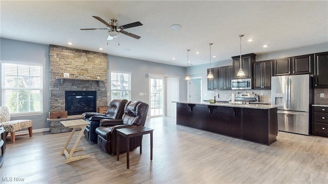 kitchen featuring a ceiling fan, open floor plan, appliances with stainless steel finishes, and a wealth of natural light