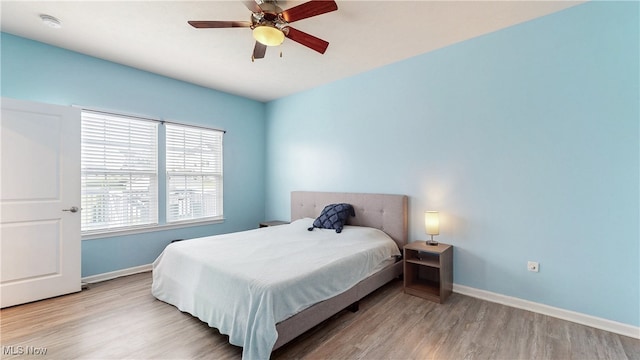 bedroom featuring baseboards, ceiling fan, and wood finished floors