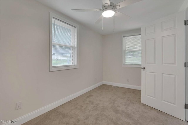 unfurnished bedroom with baseboards, light carpet, and ceiling fan
