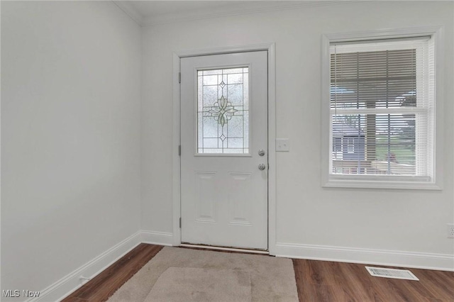 doorway to outside with baseboards, ornamental molding, dark wood-style flooring, and visible vents