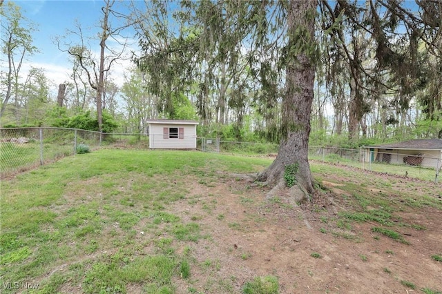 view of yard with an outdoor structure, a fenced backyard, and a shed