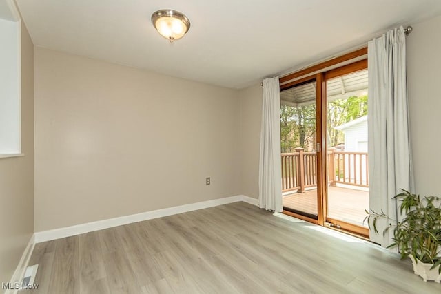 unfurnished room featuring baseboards and light wood finished floors