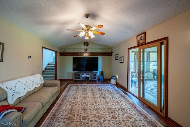living area with ceiling fan, vaulted ceiling, stairs, and wood finished floors