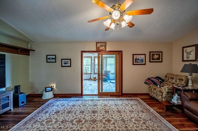 living room featuring a textured ceiling, baseboards, a ceiling fan, and wood finished floors