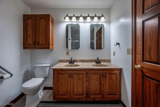 full bathroom with double vanity, a sink, baseboards, and toilet