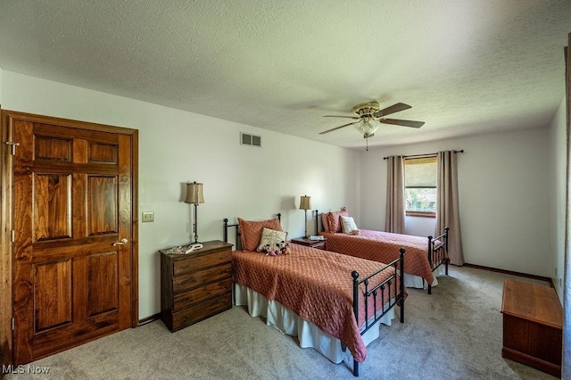 bedroom with ceiling fan, light colored carpet, a textured ceiling, baseboards, and visible vents