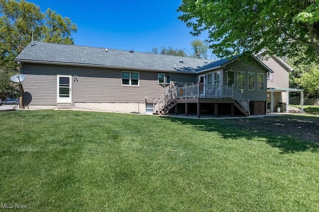 rear view of house with roof with shingles, a wooden deck, a lawn, and stairway