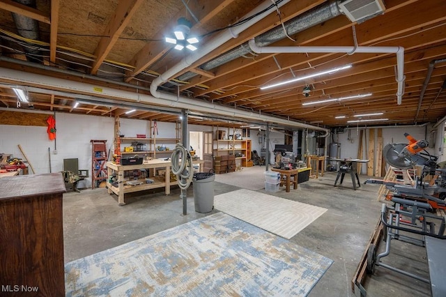 unfinished below grade area featuring a workshop area and water heater