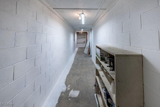 hallway featuring concrete flooring and concrete block wall