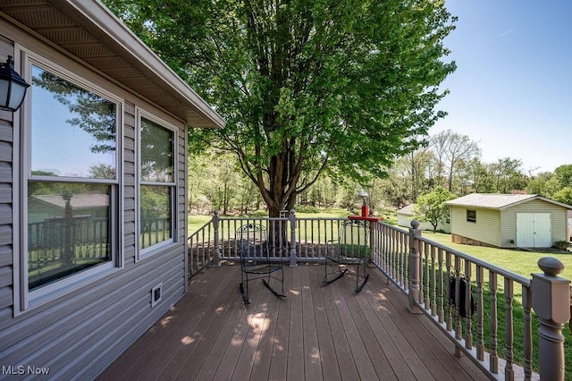 wooden terrace featuring a lawn, an outbuilding, and a storage unit