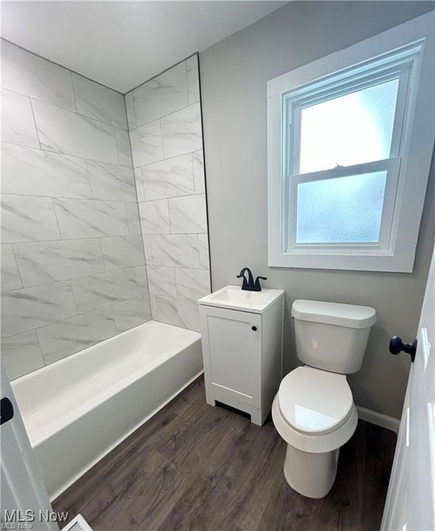 full bath featuring vanity, shower / bathtub combination, wood finished floors, toilet, and baseboards