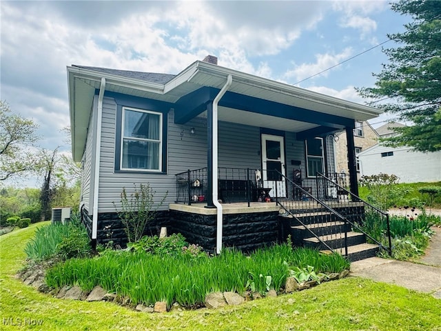 bungalow-style home with a porch, central AC, and a chimney