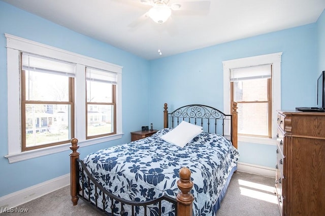 bedroom with carpet floors, a ceiling fan, baseboards, and multiple windows