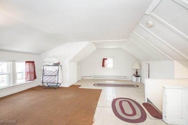 additional living space with a baseboard heating unit and vaulted ceiling