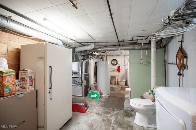 unfinished below grade area with heating unit, gas water heater, washer / clothes dryer, and freestanding refrigerator