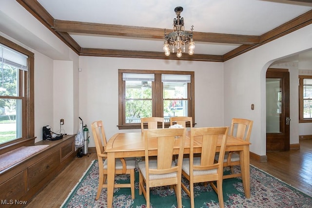 dining space with arched walkways, baseboards, an inviting chandelier, and wood finished floors