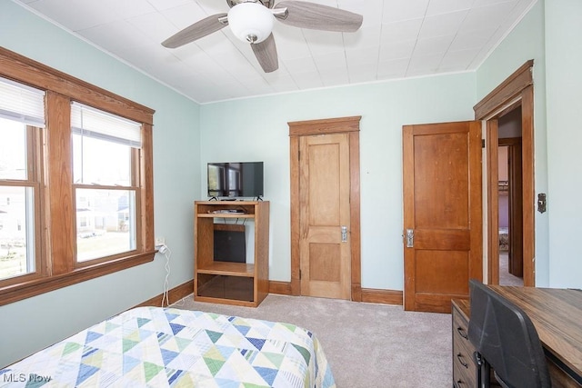 carpeted bedroom featuring baseboards, ornamental molding, and a ceiling fan