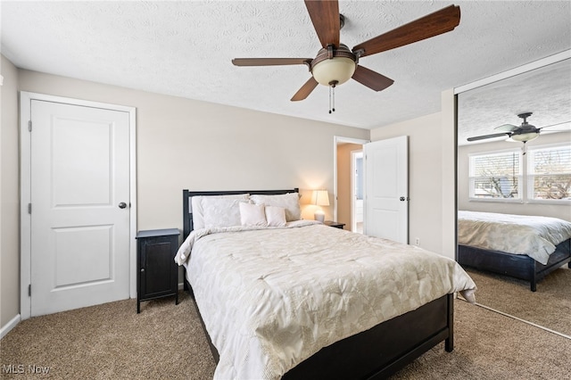 bedroom with carpet floors, ceiling fan, and a textured ceiling