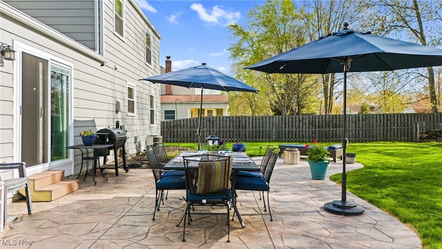 view of patio / terrace with outdoor dining area, a fenced backyard, and area for grilling