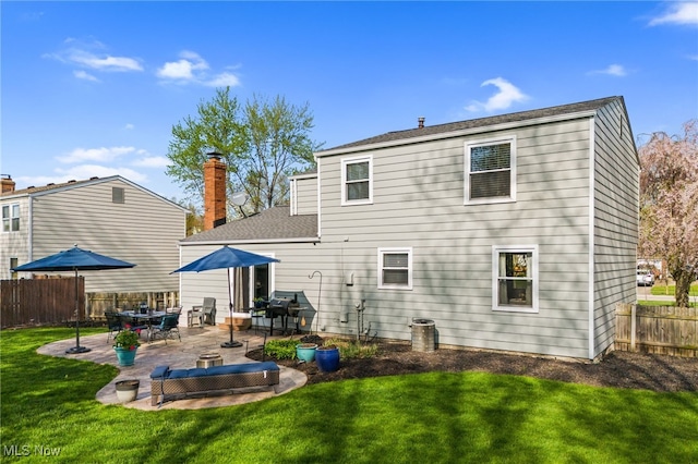 back of property featuring a lawn, a patio area, fence, and roof with shingles