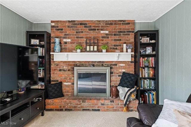living area featuring carpet flooring, wooden walls, ornamental molding, and a fireplace
