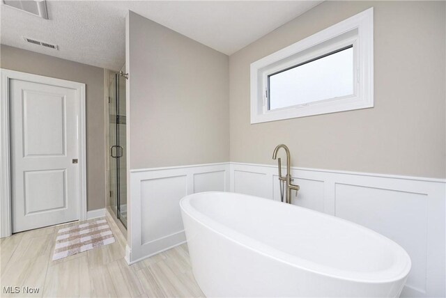 2716 Rocky Ridge Dr, Westlake, OH 44145 - bathroom with wainscoting, a soaking tub, a shower stall, and visible vents