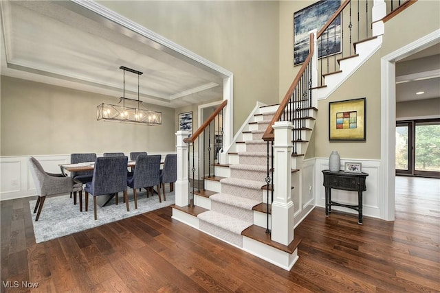 2716 Rocky Ridge Dr, Westlake, OH 44145 - staircase with an inviting chandelier, a tray ceiling, wainscoting, and wood finished floors