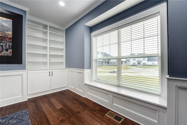 2716 Rocky Ridge Dr, Westlake, OH 44145 - unfurnished dining area featuring dark wood-style flooring, ornamental molding, visible vents, built in features, and a decorative wall