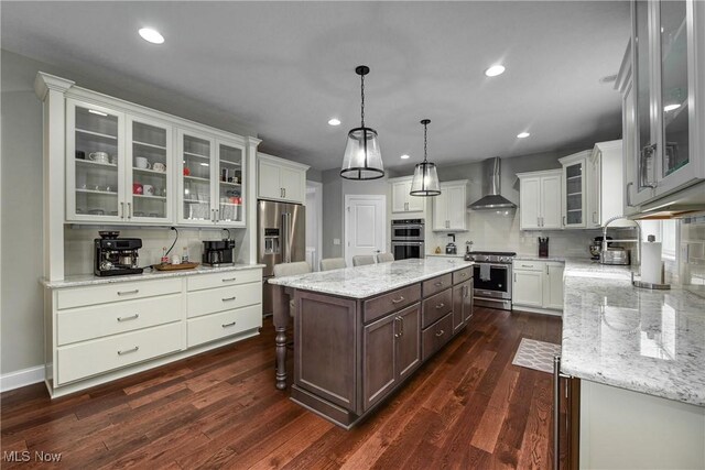 2716 Rocky Ridge Dr, Westlake, OH 44145 - kitchen featuring wall chimney range hood, dark wood-type flooring, recessed lighting, a kitchen island, and appliances with stainless steel finishes