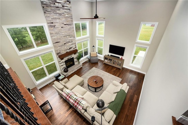 2716 Rocky Ridge Dr, Westlake, OH 44145 - living area featuring a ceiling fan, baseboards, a stone fireplace, dark wood-style flooring, and a towering ceiling