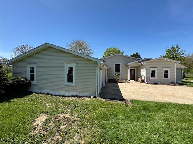 back of house with a patio and a lawn
