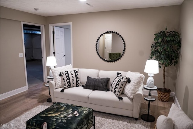 living area with baseboards, wood finished floors, and visible vents