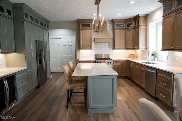 kitchen featuring a center island, a sink, premium range hood, wine cooler, and stainless steel appliances