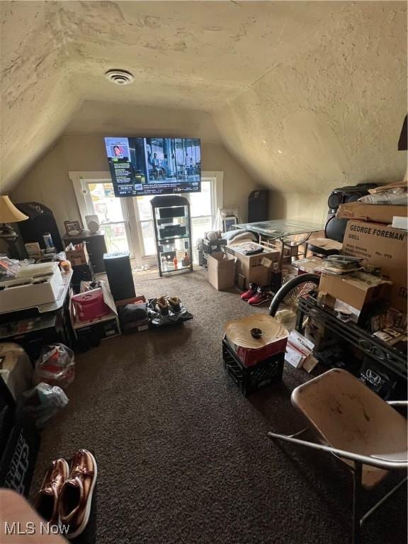 interior space with carpet floors, visible vents, and lofted ceiling