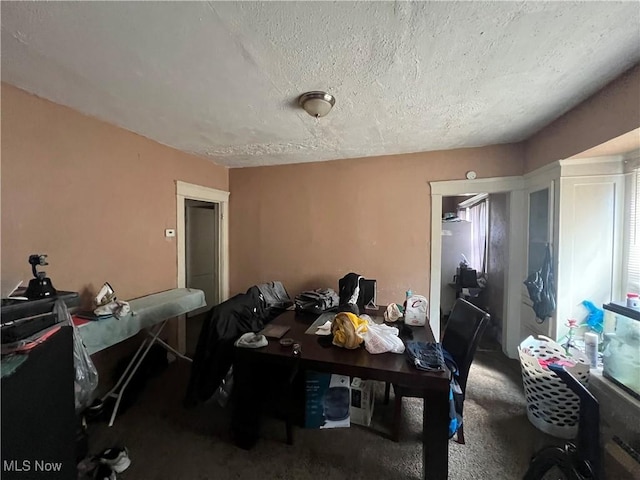 dining area featuring carpet floors and a textured ceiling