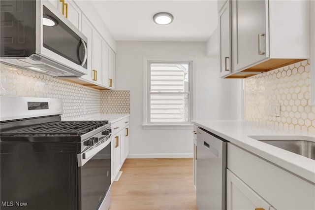 kitchen featuring light countertops, decorative backsplash, and stainless steel appliances