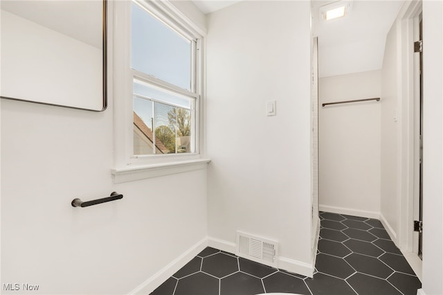 interior space featuring baseboards, visible vents, and tile patterned flooring