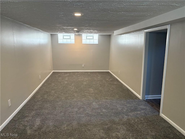 basement with baseboards, a textured ceiling, and carpet
