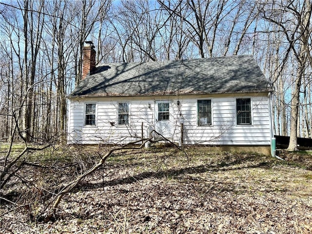 back of house featuring a chimney