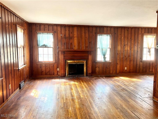 unfurnished living room with visible vents, plenty of natural light, hardwood / wood-style flooring, and a fireplace