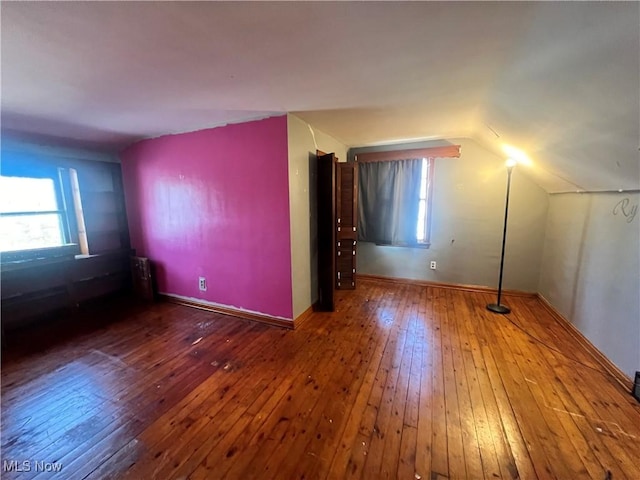 bonus room featuring baseboards, vaulted ceiling, and hardwood / wood-style floors